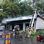 Firefighters overhaul a garage on fire on South St