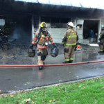 A Meadville Central firefighter removes propane tanks from a garage on fire on South St